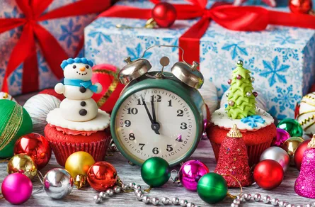 Christmas decorations around clock, cupcakes and ornaments