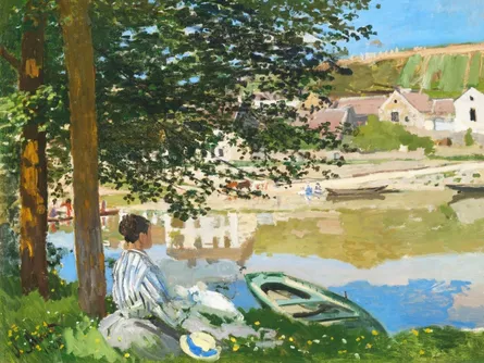 Person sitting in grass by lake