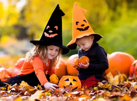 Two kids playing in leaves