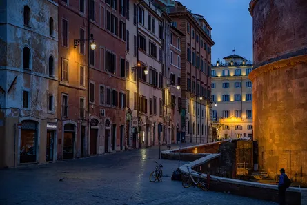 Street lights illuminate cobblestone road