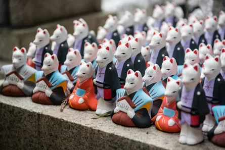 Several cat figurines sitting on bench