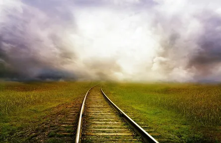 Empty railroad tracks in clouds